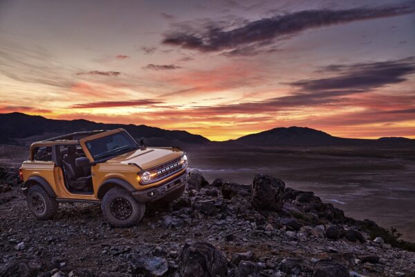 Ford Bronco in desert sunset landscape.
