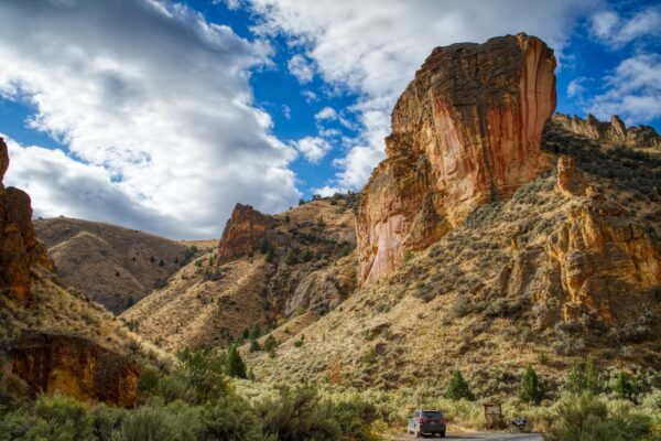 A Subaru next to a large rock formation in Jordan Valley, Oregon