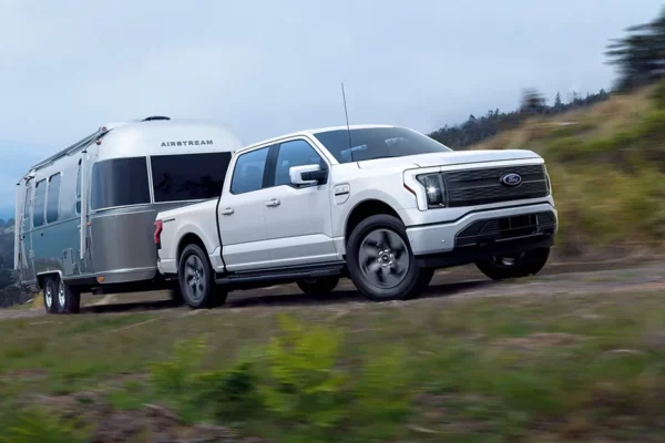 Ford F-150 Lightning pulling an Airstream trailer near the coast.