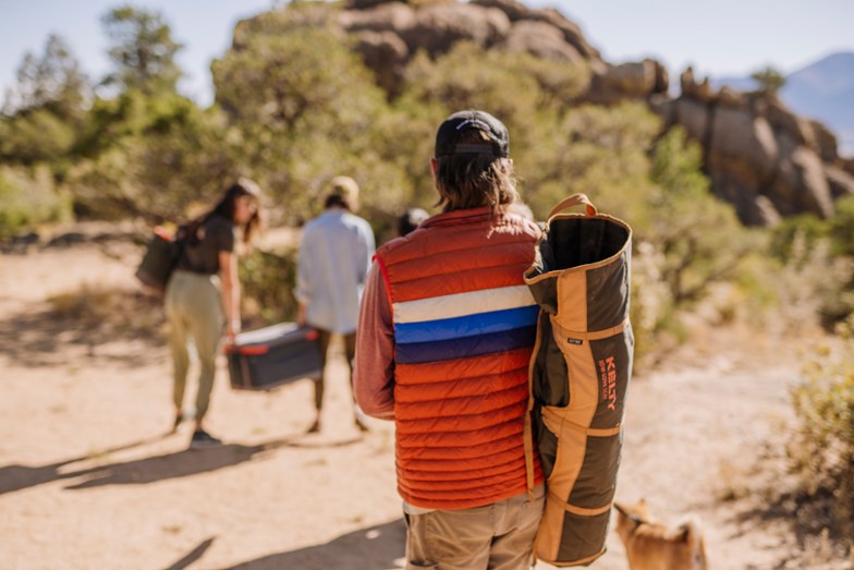 Man carrying a Kelty Lowdown Chair slung over his shoulder.