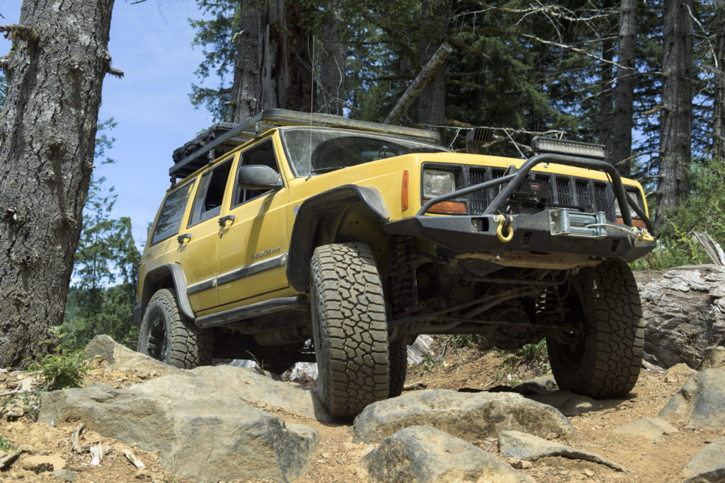 Jeep XJ crawling through rocky terrain with Falken WILDPEAK A/T3W tires.