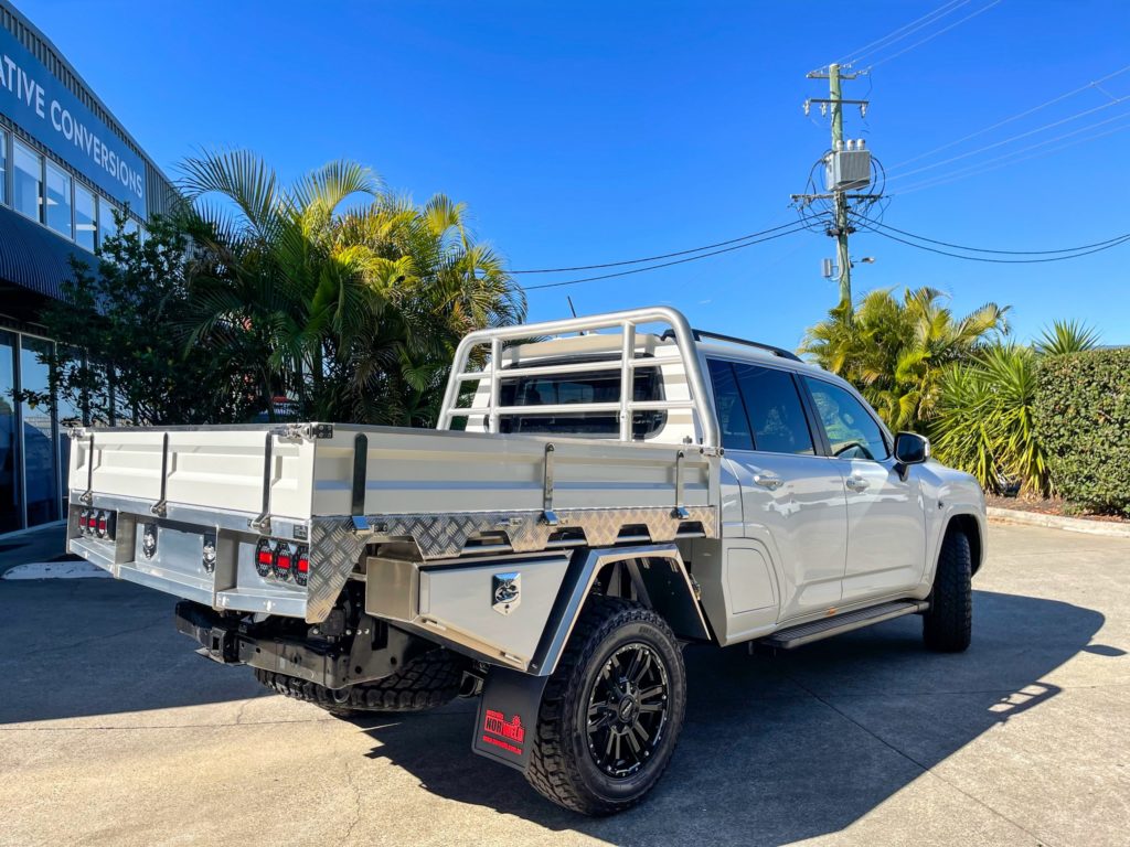 Rear 3/4 view of the converted 300 Series Land Cruiser to a Dual Cab Ute with rear tray.