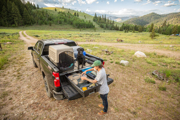 Man accessing his DECKED Drawer System in the backcountry.